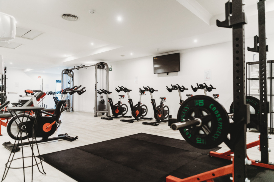 A gym floor with spin bikes and weight equipment