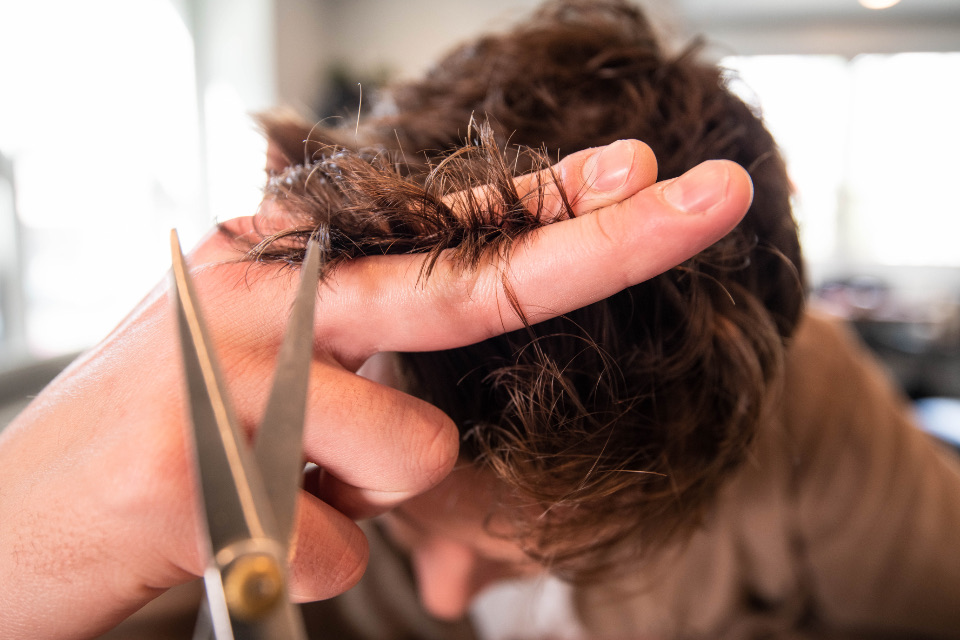 A hairdresser cutting a client's hair in a salon